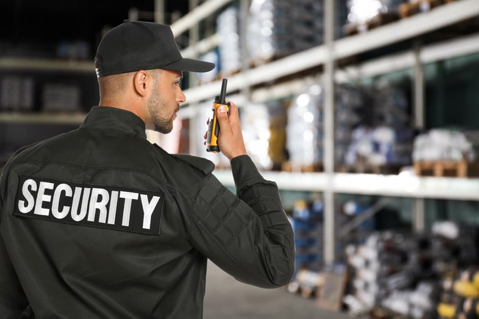 A warehouse security guard monitoring the facility for safety and loss prevention.